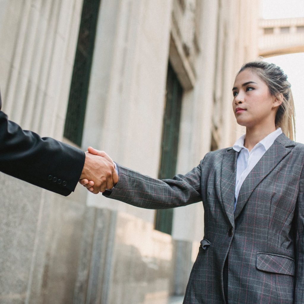 young business woman shake hands with unrecognizable man